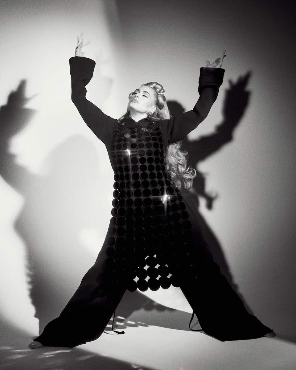 Adele wearing a black dress, trousers and jumper which are all Marc Jacobs. The photo is in black and white, shot by Charlotte Wales for The Face magazine.