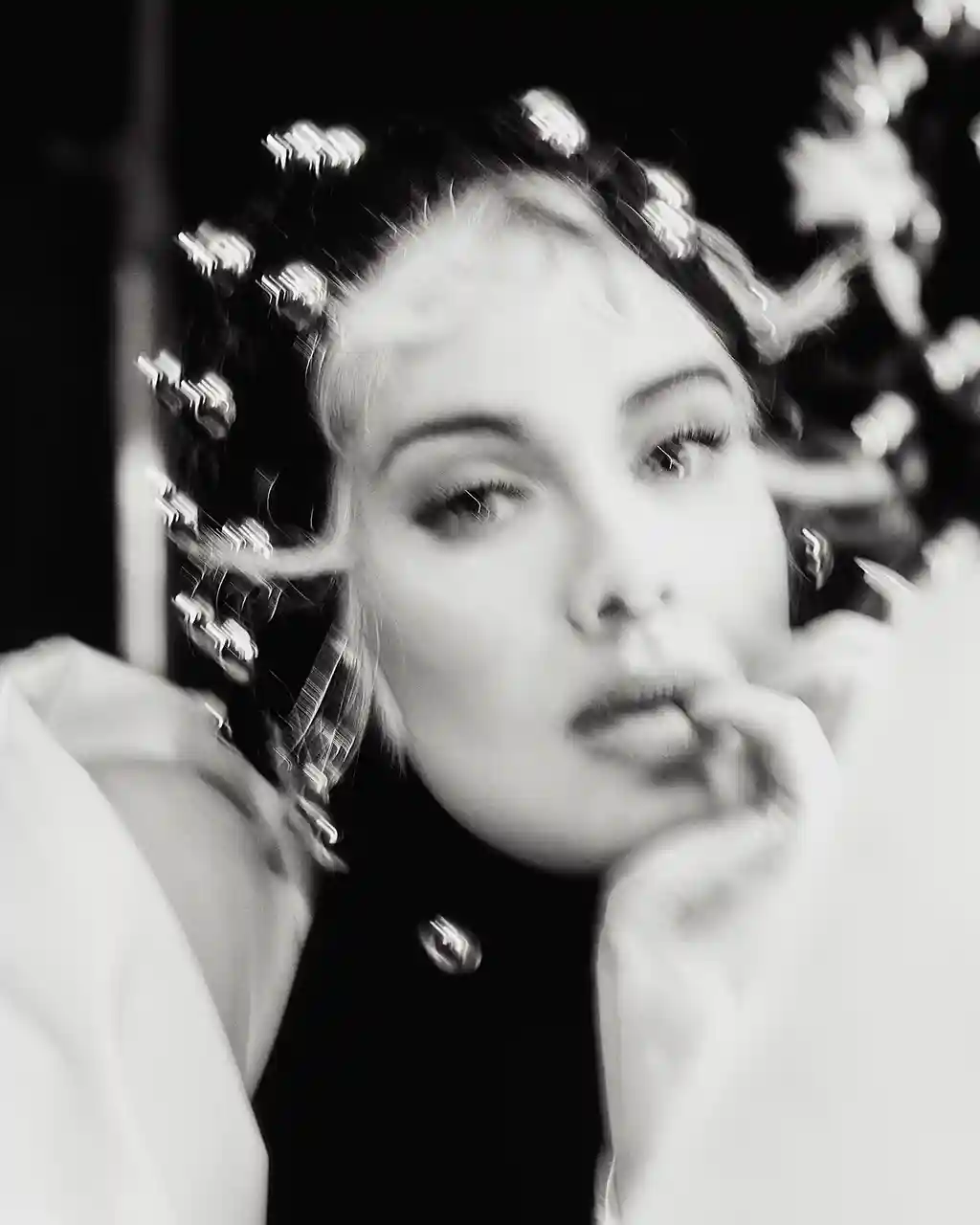 Shot in black and white, wearing a black dress, a while coat and a headpiece – all are by Azzedine Alaïa.