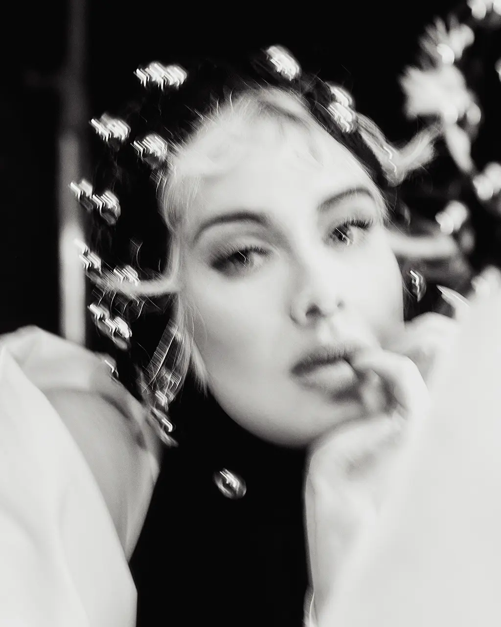 Shot in black and white, wearing a black dress, a while coat and a headpiece – all are by Azzedine Alaïa.